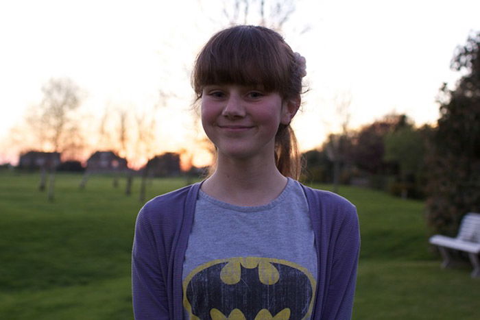 A portrait of a young girl posing outdoors