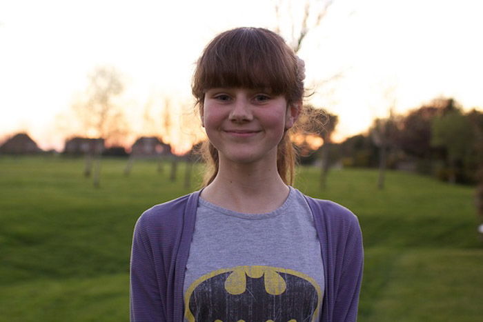 A portrait of a young girl posing outdoors