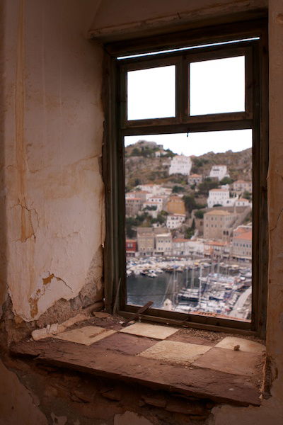 Photo of a greek harbour framed by an old window as an example of frame within a frame composition