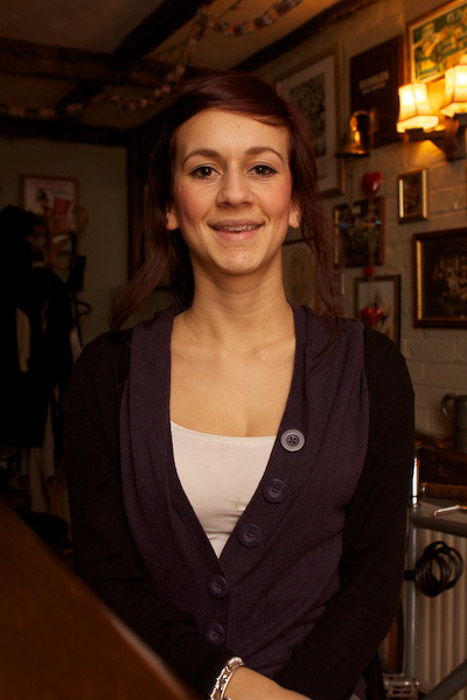 A portrait of a female model posing indoors, shot using a flash