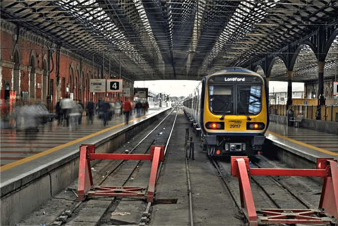 An empty train station with trains on the tracks.