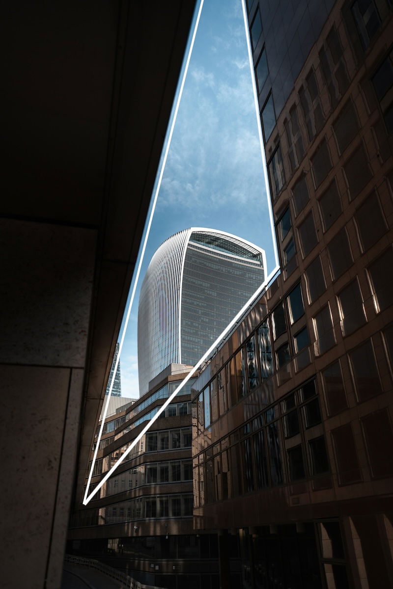 A building and sky framed by a triangle in photography made by other buildings