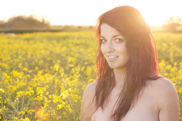 Photo of a young woman in the field of yellow flowers demonstrating editing with white brightness