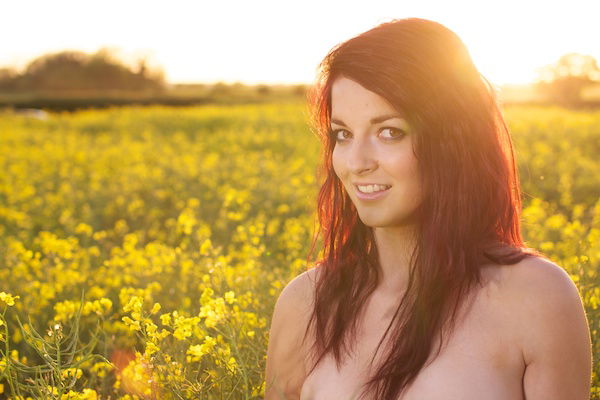 Photo of a young woman in the field of yellow flowers demonstrating editing with vibrancy