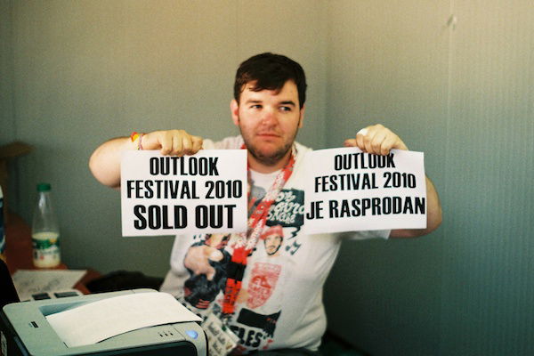 A man holds up two pieces of paper with text - Window Light for Portraits