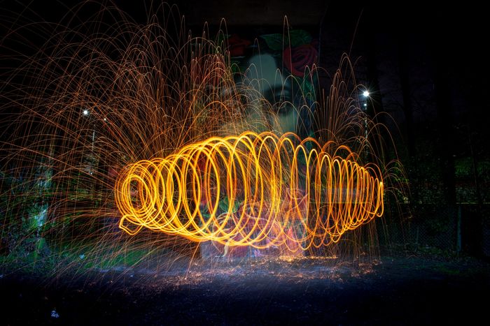 Circular orange light trails and sparks created by steel wool for creative lighting ideas