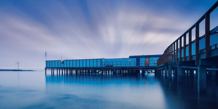 photo of a pier with moving clouds shot with long exposure