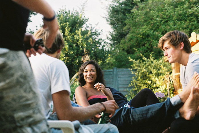 A candid portrait photo of friends chatting in a garden