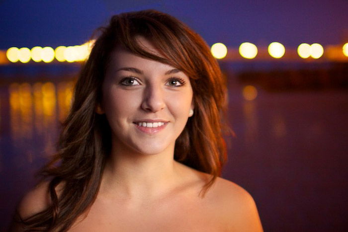 A female model posing outdoors in low light