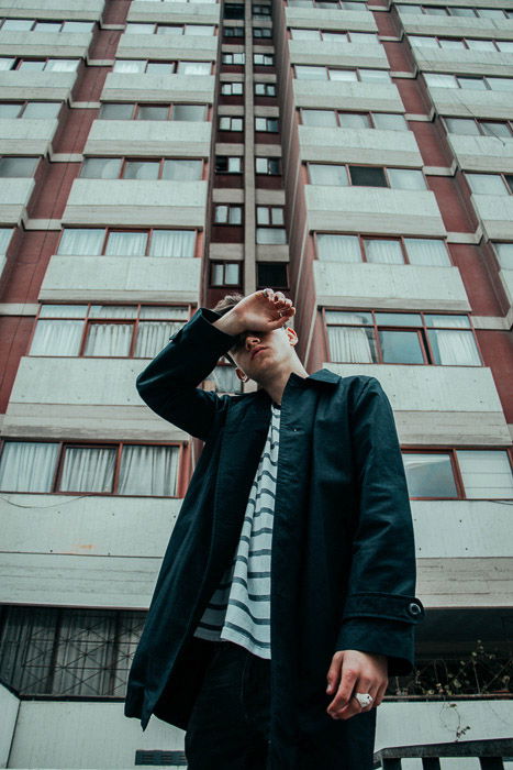 A candid portrait of a man standing in front of a tall building