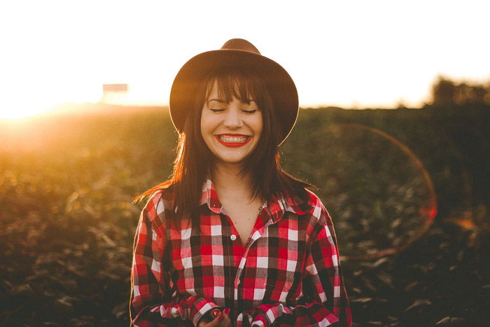 Portrait photo of a female model in black hat taken at golden hour