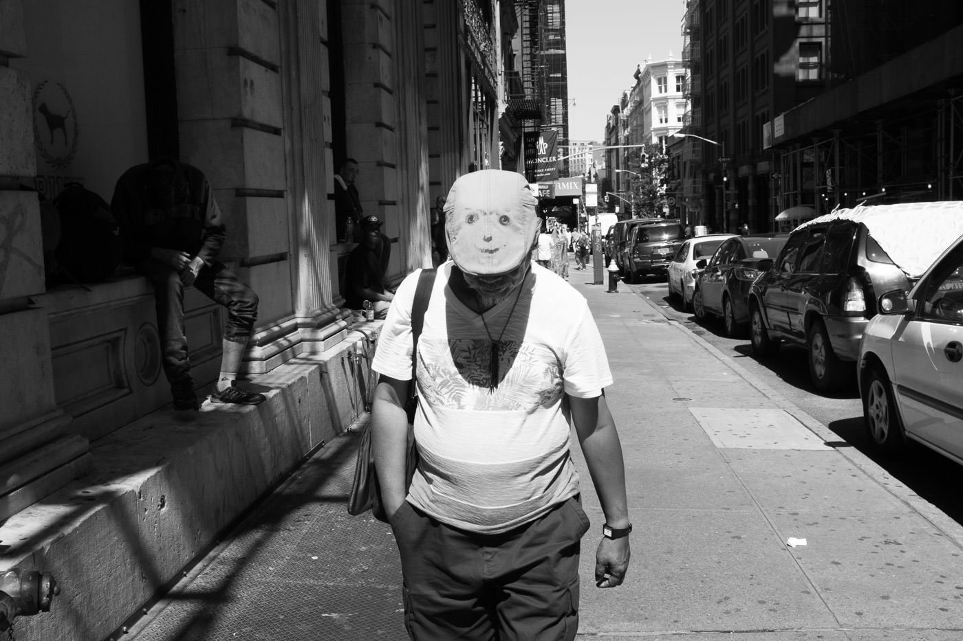 Street photography: Candid snap of man with smiley face on top of hat