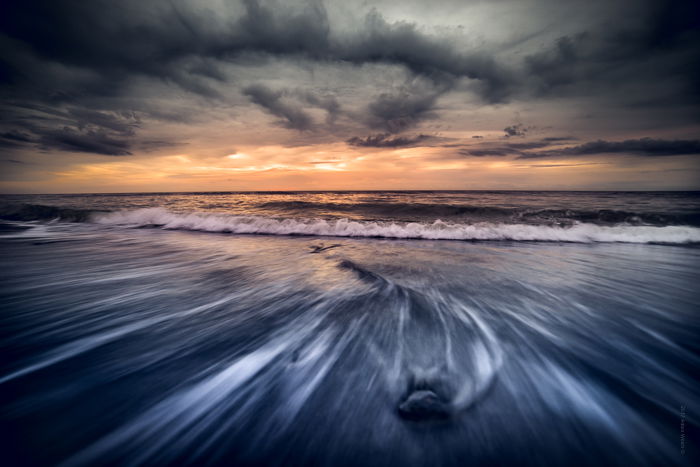 Dramatic Weather: Dark cloud cover at sunset on a beach