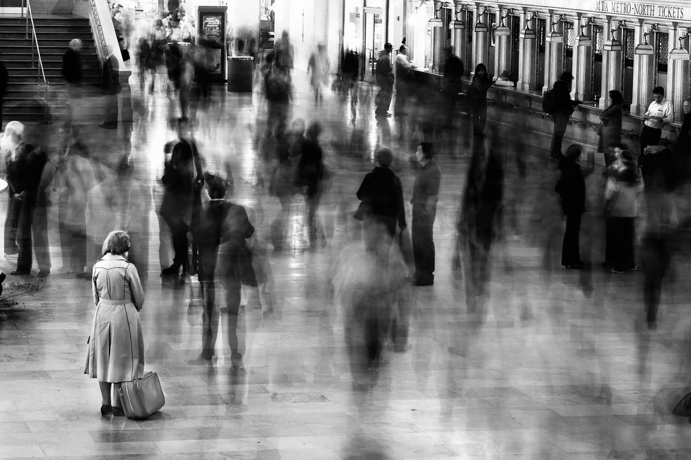 Traveler standing still in busy hall of Grand Central Station