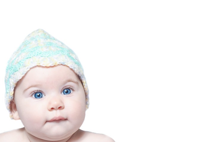 High key portrait of a baby wearing hat