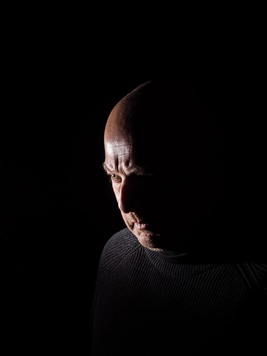 Low key portrait of a male model illustrating short lighting