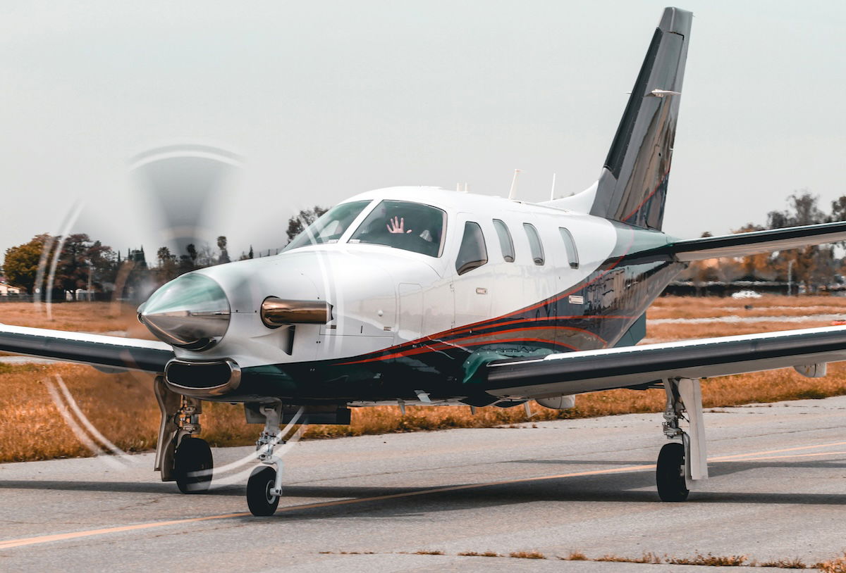 A plane taxiing on an airstrip with front rotor blades spinning as an example of aviation photography