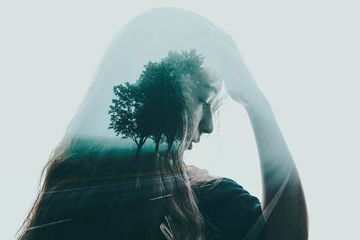 artistic photography of a young woman's self-portrait double exposed with a lone tree