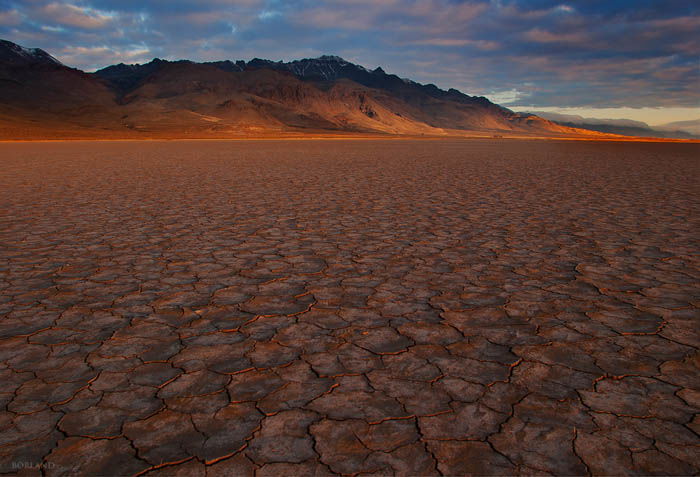 Desert photography showing the use of pattern in the foreground to draw the viewer's eye to the mountains on the horizon