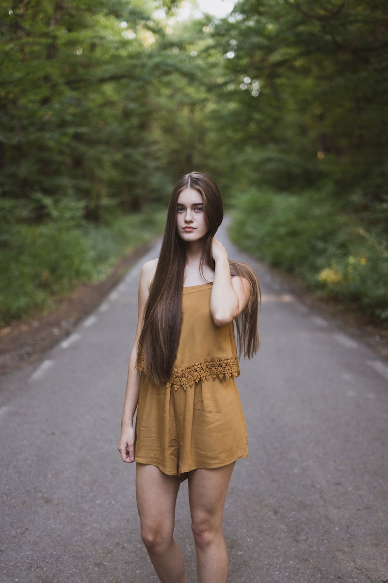 Woman standing with on hand up behind her neck