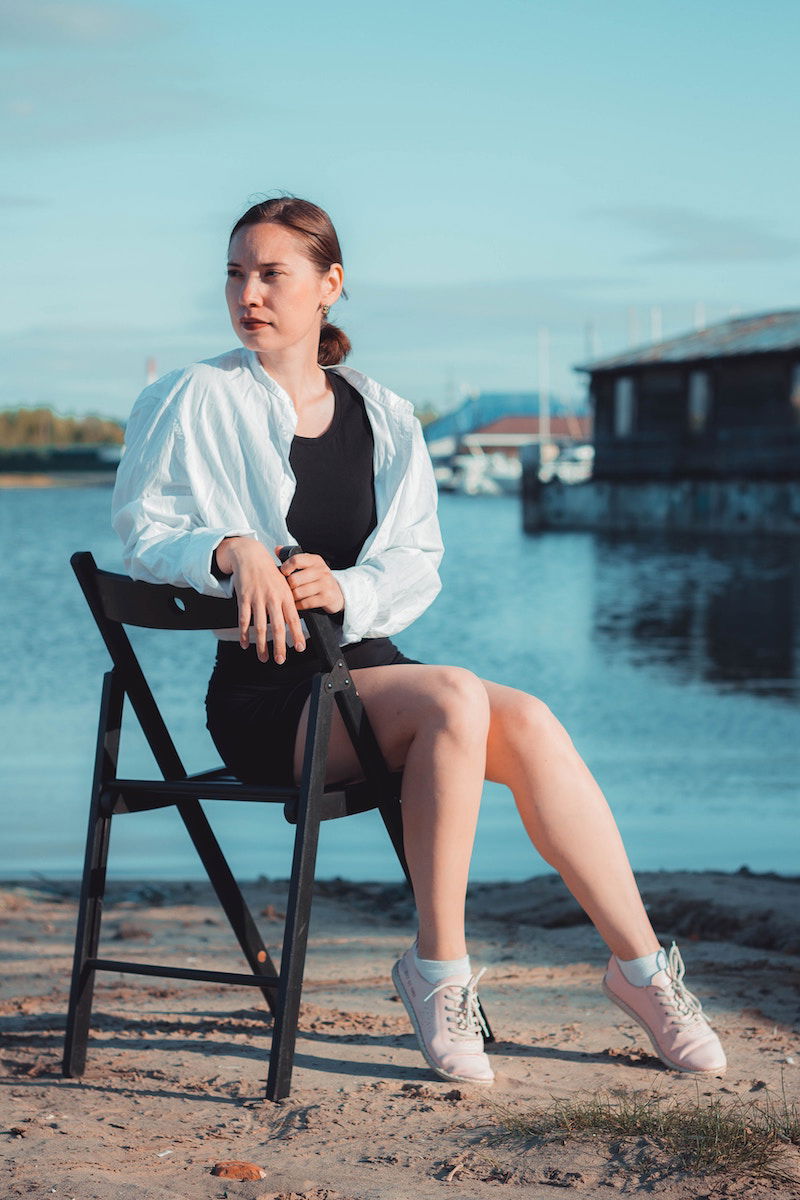 Woman sitting on a folding char with her toes pointed