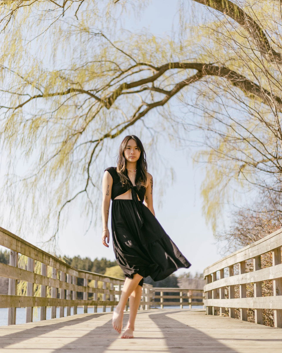 A woman walking on a bridge under a tree