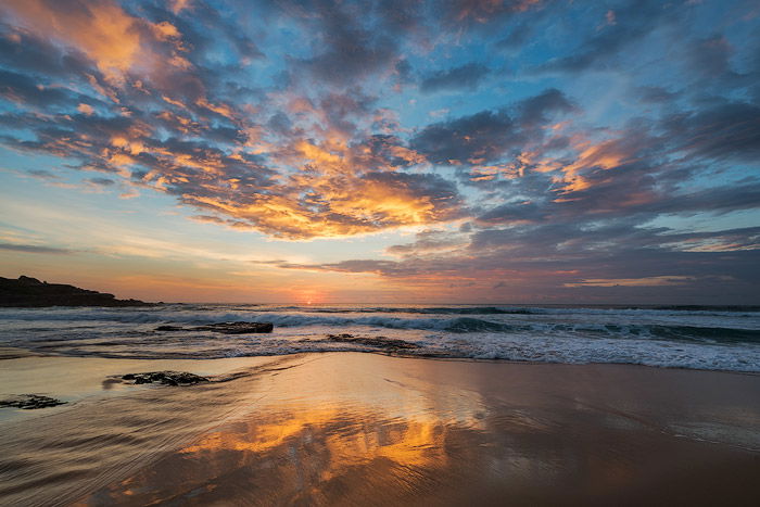 sand reflecting the sunset on a beach at evening time