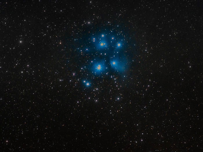 A night sky photography shot of Pleiades and their classic blue nebulosity