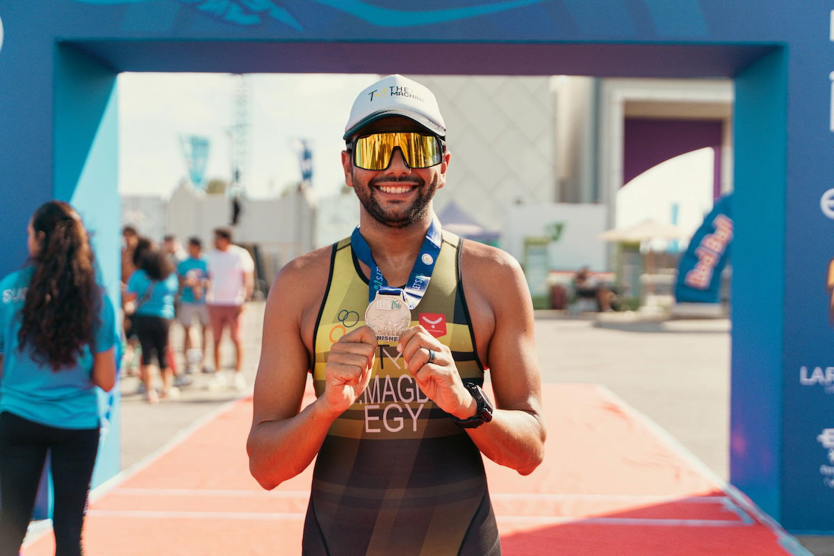 A runner holding up a finish medal as an example of marathon photography