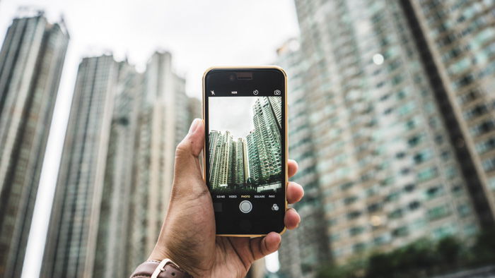 A hand holding up a phone for smartphone photography