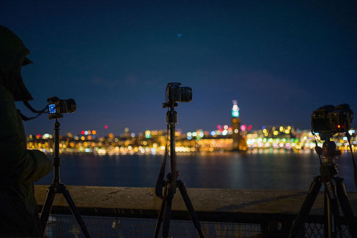 photo of tripods at night on a riverbank