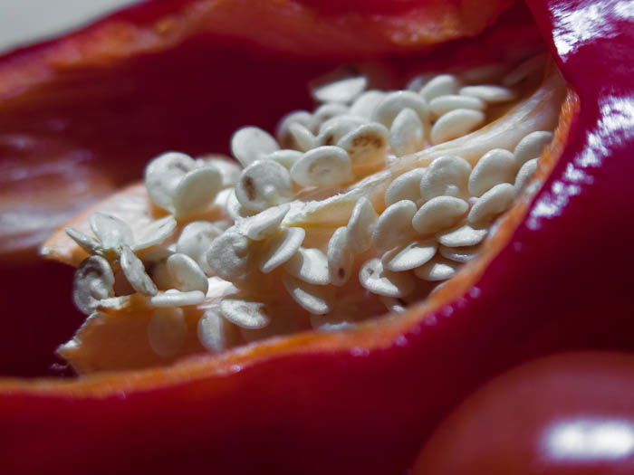 A red bell pepper cut, seeds showing