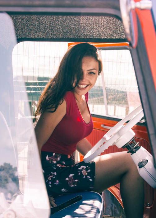 A female photography model sitting in the drivers seat of a vehicle - fashion photography composition