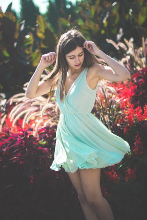 A female photography model posing outdoors wearing flowy light blue summer dress - fashion photography composition