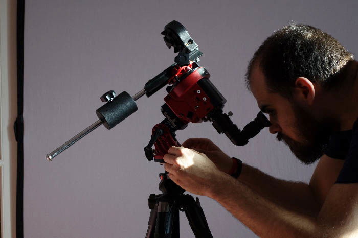 A man is working on a telescope. 