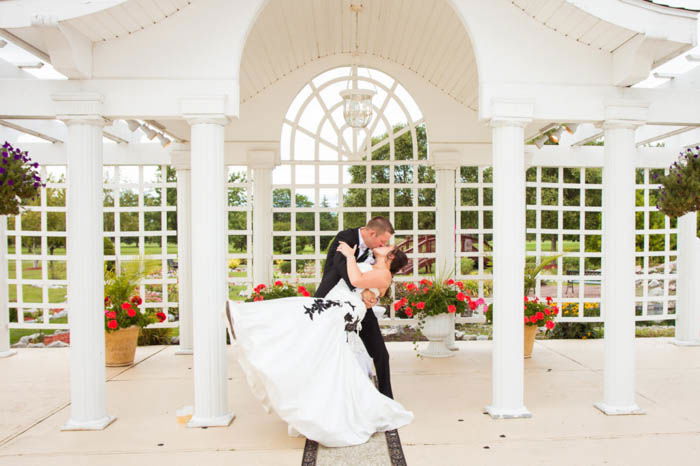 Wedding portrait of the couple posing outdoors with the dip kiss