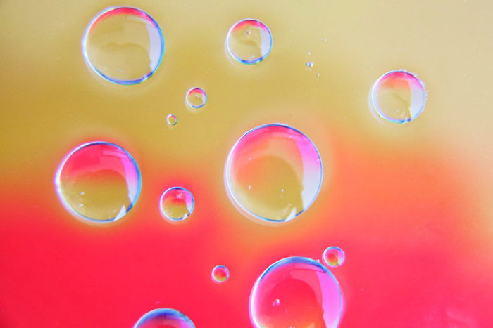 bright pink and sand background with 13 clear bubbles created from photography with Oil and Water