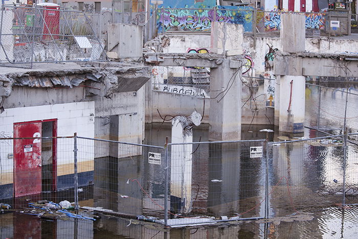 Busy scene of broken buildings, fences and water - architectural photography after the earthquakes in Christchurch, New Zealand.