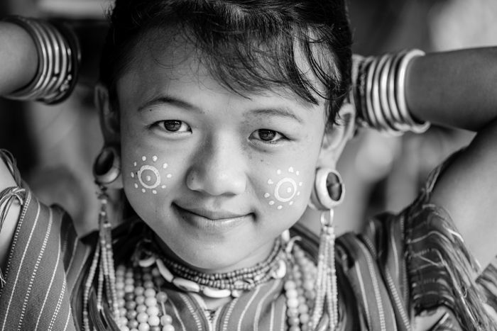 portrait of a young Kayaw girl putting her hair up