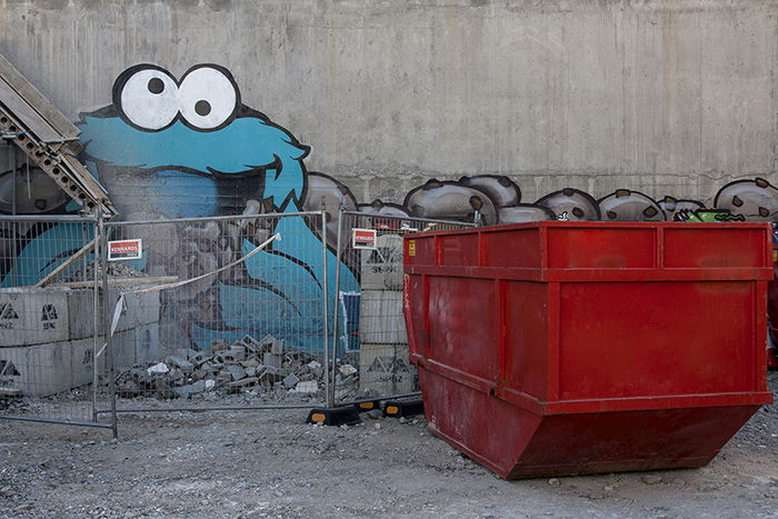 Graffiti of cookie monster character on a wall behind a building site. Creative street photography