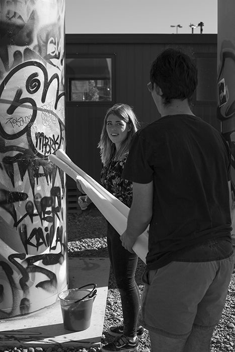 Black and white photo of CHUZKOS artists installing a photographic street art exhibition. Creative street photography