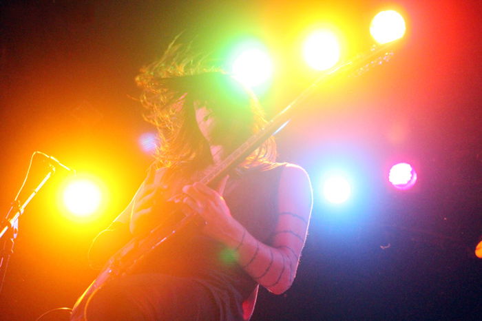 Colorful concert photography of a guitar player from low angle.