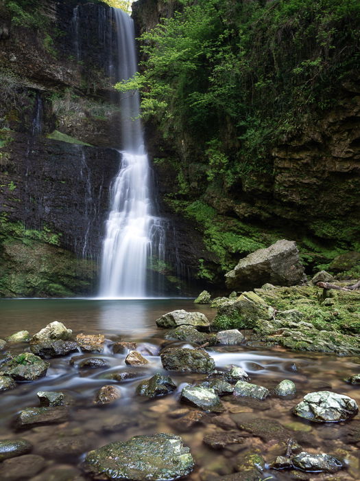 A beautiful flowing waterfall surrounded by green moss and rocks