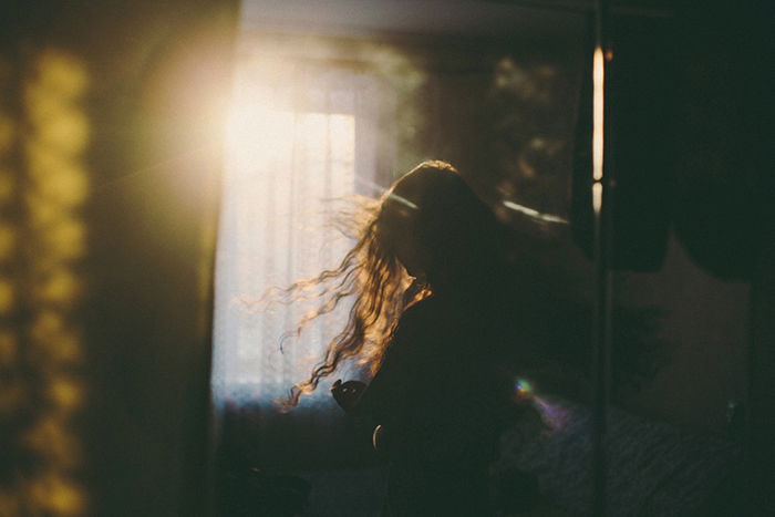 Dreamy low light silhouette of a woman standing - faceless portrait photography