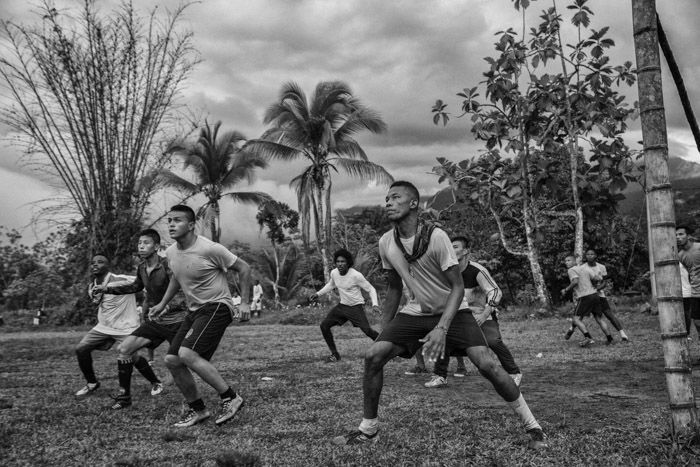 Black and white photography of men playing soccer in Cambodia by Juan Arredondo.