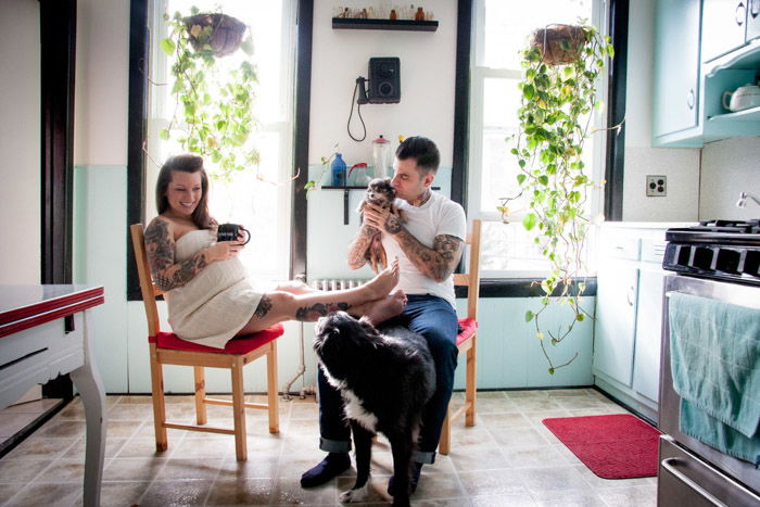 Photo of a couple with 2 dogs relaxing in the kitchen by Nina Robinson