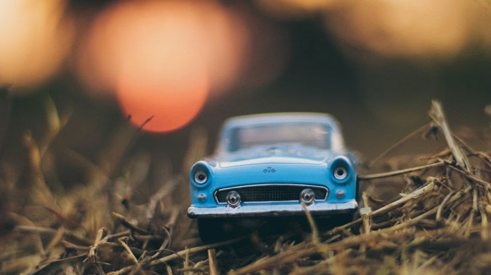 A photo of a toy blue car on grass