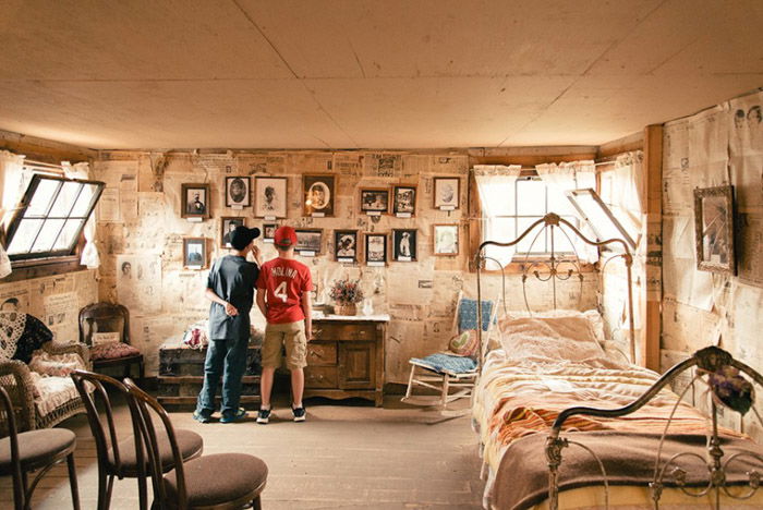 A photo of two boys in an old fashioned bedrhotos on the wall.