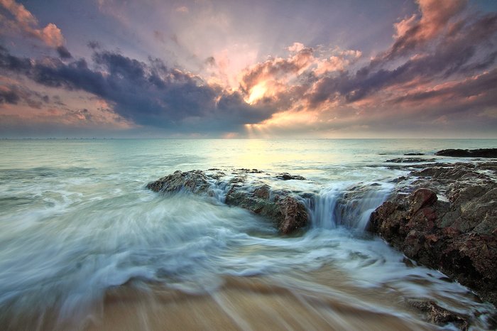 A stunning image of a rocky coastline at sunset.