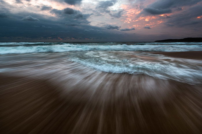 Impressive reducing wave seascape with fiery sunset sky using shutter speed of 0.5 - 2 seconds. 